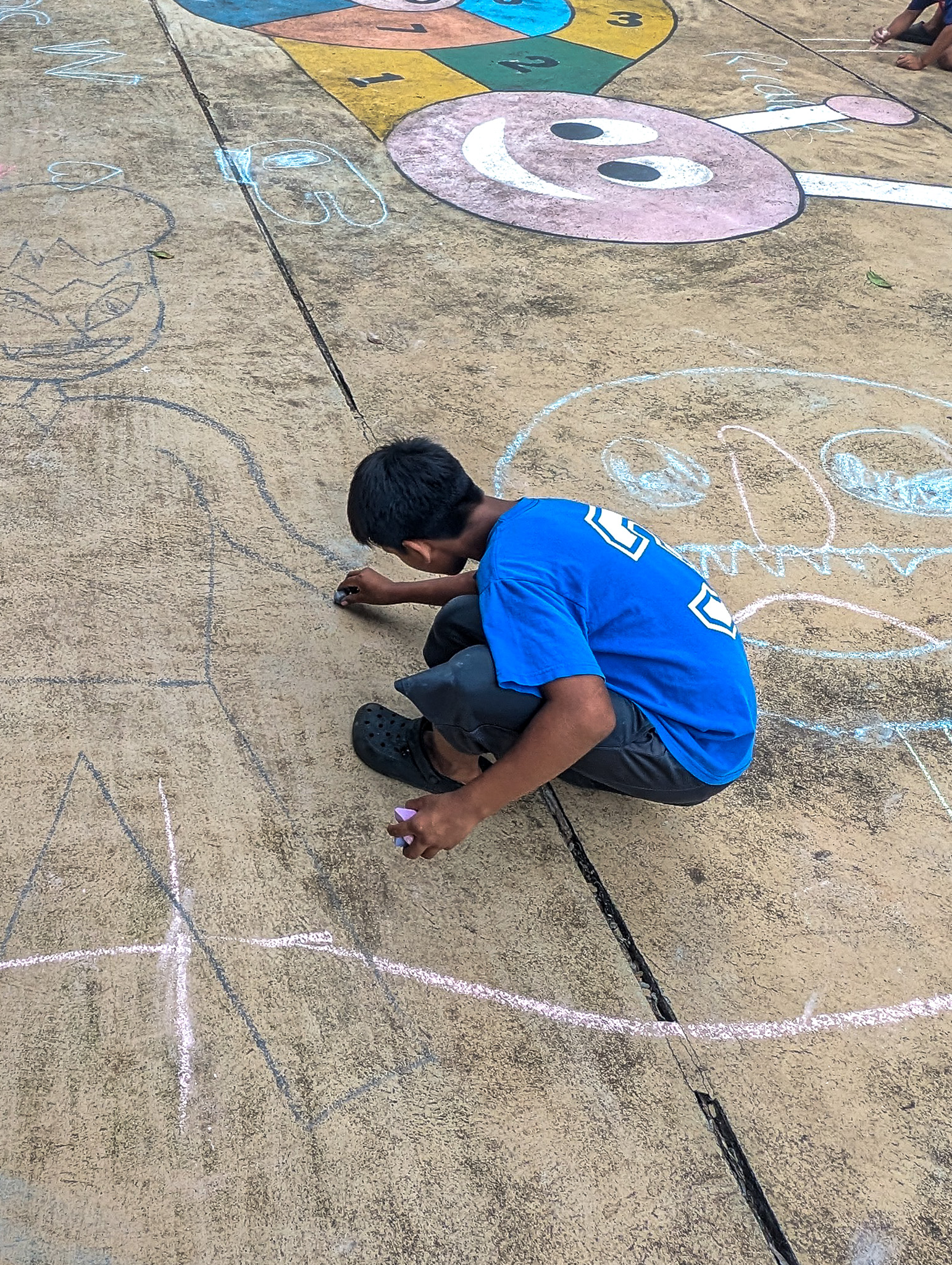 boy drawing on cement court