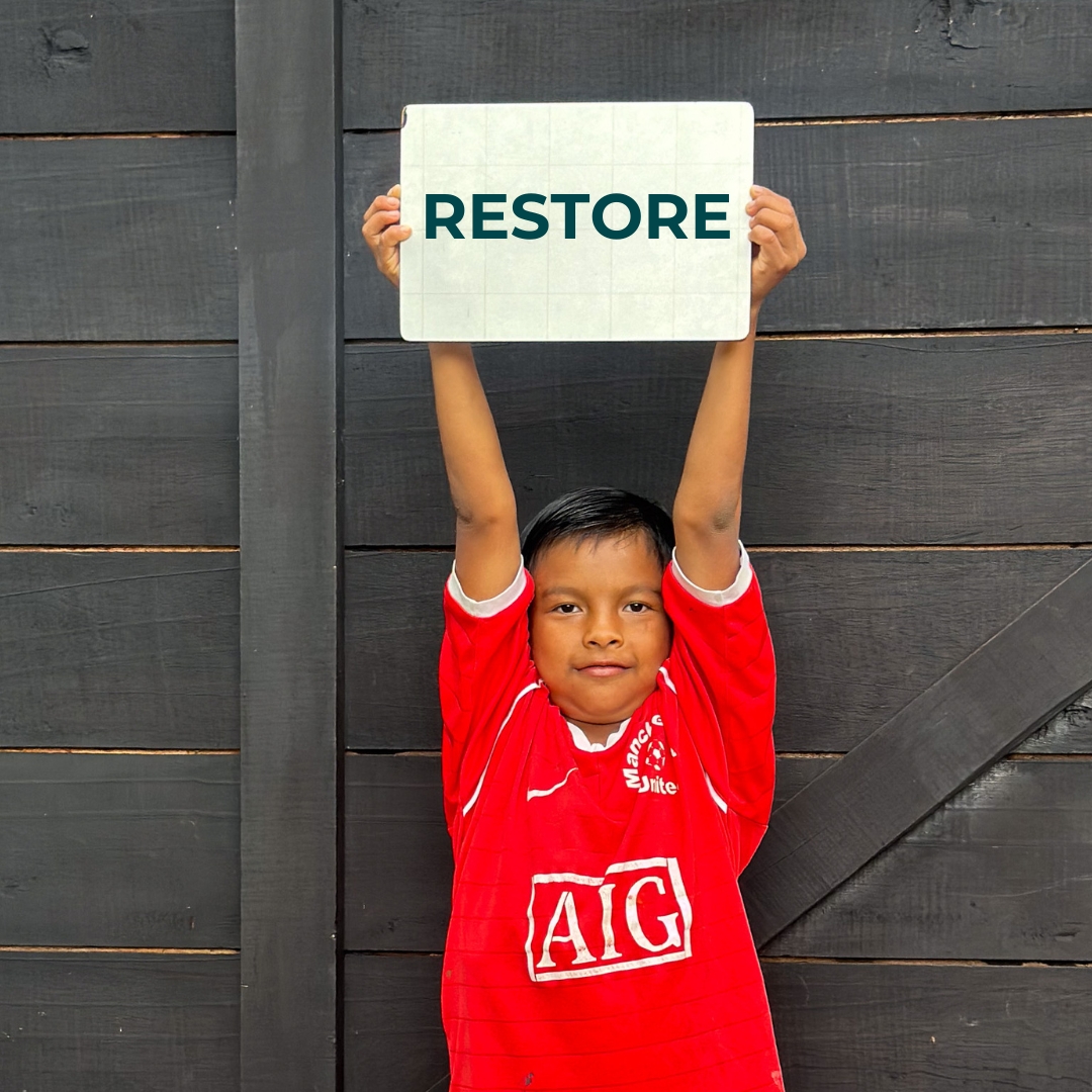 child with a sign about restore